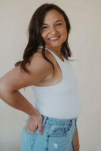 Load image into Gallery viewer, side view of model wearing the change your mind bodysuit in the color white. model has the bodysuit paired with the charleston denim.