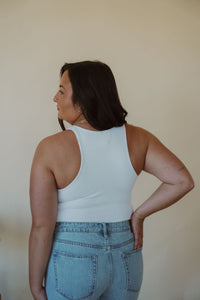 back view of model wearing the change your mind bodysuit in the color white. model has the bodysuit paired with the charleston denim.