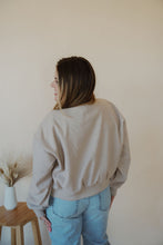 Load image into Gallery viewer, back view of model wearing the winding roads bomber jacket in the color light taupe. model has the jacket paired with the used to know bodysuit in the color biscuit and the charleston denim.
