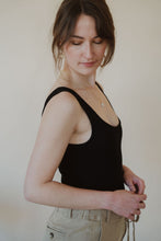 Load image into Gallery viewer, side view of model wearing the used to know bodysuit in the color black. model has the bodysuit paired with the in another life skirt.