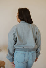 Load image into Gallery viewer, back view of model wearing the winding roads bomber jacket in the color light grey. model has the jacket paired with the change your mind bodysuit in the color black and the charleston denim.