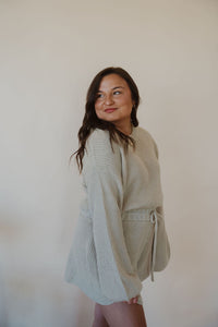 side view of model wearing the wouldn't change a thing romper in the color taupe.
