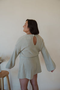 back view of model wearing the wouldn't change a thing romper in the color taupe.