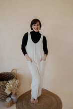 Load image into Gallery viewer, model wearing the never let me go jumpsuit in the color cream. model has the jumpsuit paired with the all along top in the color black.