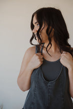 Load image into Gallery viewer, detail view of model wearing the carly denim romper in the color charcoal. model has the romper paired with the these days top in the color charcoal.