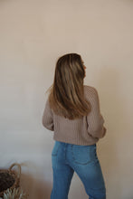 Load image into Gallery viewer, back view of model wearing the patiently waiting sweater in the color oat. model has the sweater paired with the aurora denim.