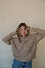 Load image into Gallery viewer, front view of model wearing the patiently waiting sweater in the color oat. model has the sweater paired with the aurora denim.