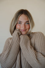 Load image into Gallery viewer, detail view of model wearing the patiently waiting sweater in the color oat. model has the sweater paired with the aurora denim.
