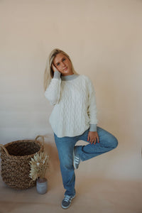 front view of model wearing the looking back sweater. model has the sweater paired with the aurora denim.