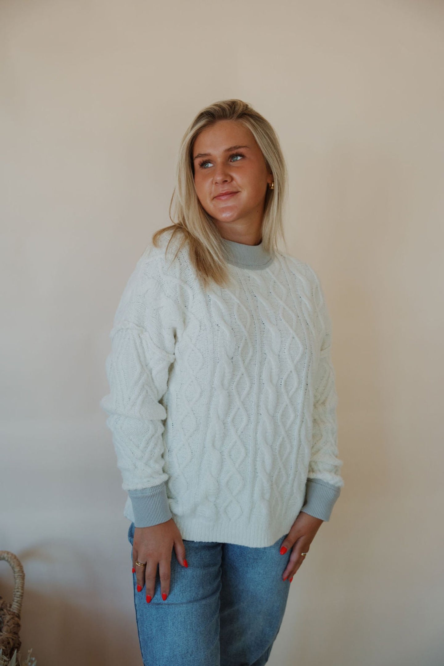 front view of model wearing the looking back sweater. model has the sweater paired with the aurora denim.