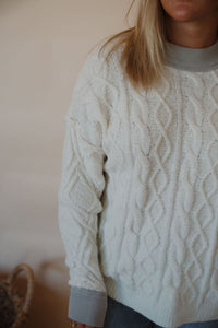 detail view of model wearing the looking back sweater. model has the sweater paired with the aurora denim.