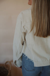 detail view of model wearing the only just begun jacket in the color beige. model has the jacket paired with the aurora denim.