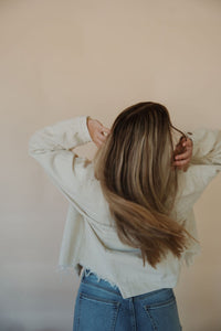 back view of model wearing the only just begun jacket in the color beige. model has the jacket paired with the aurora denim.