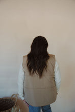 Load image into Gallery viewer, back view of model wearing the long way home puffer vest in the color mocha. model has the vest paired with the play it cool sweater and the aurora denim.