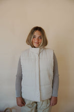 Load image into Gallery viewer, front view of model wearing the long way home puffer vest in the color ecru. model has the vest paired with the better days top and the oakland chinos.