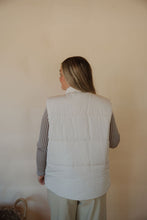 Load image into Gallery viewer, back view of model wearing the long way home puffer vest in the color ecru. model has the vest paired with the better days top and the oakland chinos.