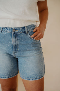 detail view of model wearing the austin denim shorts. model has the shorts paired with the look after you sweater vest.