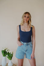 Load image into Gallery viewer, front view of model wearing the used to know bodysuit in the color navy. model has the top paired with the dakota denim shorts and the dainty mallory necklace.