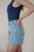 Load image into Gallery viewer, side detail view of model wearing the dakota denim shorts. model has the shorts paired with the used to know bodysuit in the color navy and the dainty mallory necklace.