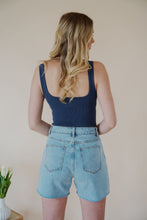 Load image into Gallery viewer, back view of model wearing the used to know bodysuit in the color navy. model has the top paired with the dakota denim shorts and the dainty mallory necklace.