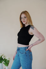 Load image into Gallery viewer, side view of model wearing the forever yours top in the color black. model has the top paired with a pair of medium wash denim.