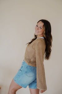 side view of model wearing the ocean avenue cardigan in the color taupe. model has the cardigan paired with the forever yours top in the color white and the austin denim shorts.