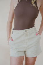 Load image into Gallery viewer, close detail front view of model wearing the parker denim shorts. model has the shorts paired with the change your mind bodysuit in the color walnut and the dainty mallory necklace.