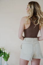 Load image into Gallery viewer, back view of model wearing the parker denim shorts. model has the shorts paired with the change your mind bodysuit in the color walnut and the dainty mallory necklace.