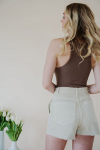 back view of model wearing the parker denim shorts. model has the shorts paired with the change your mind bodysuit in the color walnut and the dainty mallory necklace.