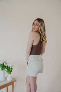 back side view of model wearing the parker denim shorts. model has the shorts paired with the change your mind bodysuit in the color walnut and the dainty mallory necklace.