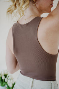 close back view of model wearing the change your mind bodysuit in the color walnut. model has the top paired with the parker shorts and the dainty mallory necklace.