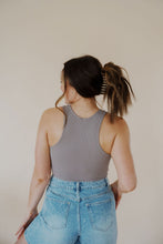 Load image into Gallery viewer, back view of model wearing the change your mind bodysuit in the color smoky taupe. model has the top paired with the austin denim shorts, an adeline claw clip, and the anna necklace.