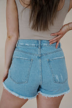 Load image into Gallery viewer, back view of model wearing the boston denim shorts. model has the shorts paired with the used to know bodysuit in the color biscuit.