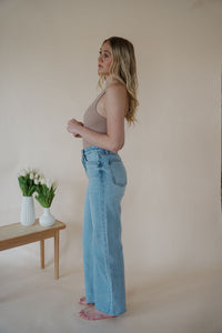 side view of model wearing the genevive denim. model has the denim paired with the change your mind bodysuit in the color light sand and the dainty mallory necklace.