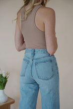 Load image into Gallery viewer, back detail view of model wearing the genevive denim. model has the denim paired with the change your mind bodysuit in the color light sand and the dainty mallory necklace.