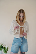 Load image into Gallery viewer, front view of model wearing the ocean avenue cardigan in the color cream. model has the cardigan paired with the forever yours top in the color macchiato and the austin denim shorts.