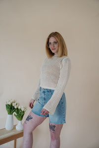 side view of model wearing the ocean avenue cardigan in the color cream. model has the cardigan paired with the forever yours top in the color macchiato and the austin denim shorts.