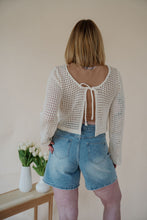 Load image into Gallery viewer, back view of model wearing the ocean avenue cardigan in the color cream. model has the cardigan paired with the forever yours top in the color macchiato and the austin denim shorts.