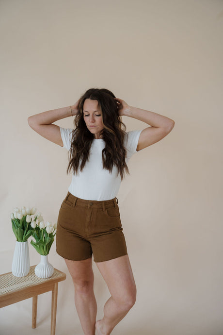 front view of model wearing the hayden denim shorts. model has the shorts paired with the take a chance bodysuit in the color off white and the anna necklace.