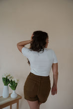 Load image into Gallery viewer, back view of model wearing the take a chance bodysuit in the color off white. model has the top paired with the hayden shorts and the anna necklace.