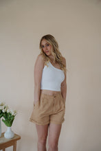 Load image into Gallery viewer, front view of model wearing the sweetest melody shorts in the color khaki. model has the shorts paired with the last to know top in the color white.