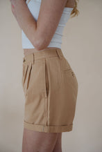 Load image into Gallery viewer, side detail view of model wearing the sweetest melody shorts in the color khaki. model has the shorts paired with the last to know top in the color white.