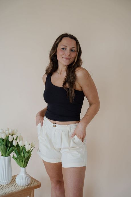 front view of model wearing the sweetest melody shorts in the color cream. model has the shorts paired with the last to know top in the color black.