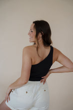 Load image into Gallery viewer, back view of model wearing the sweetest melody shorts in the color cream. model has the shorts paired with the last to know top in the color black.