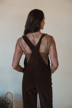 Load image into Gallery viewer, back view of model wearing the settlin&#39; down corduroy overalls in the color brown. model has the overalls paired with the here to stay top in the color brown.