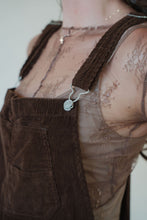 Load image into Gallery viewer, detail view of model wearing the settlin&#39; down corduroy overalls in the color brown. model has the overalls paired with the here to stay top in the color brown.