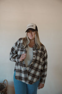 front view of model wearing the yeehaw trucker hat. model has the hat paired with the something's changed shacket and the forever yours tank in the color light beige.