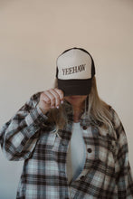 Load image into Gallery viewer, front view of model wearing the yeehaw trucker hat. model has the hat paired with the something&#39;s changed shacket and the forever yours tank in the color light beige.