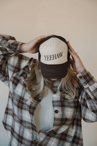 front view of model wearing the yeehaw trucker hat. model has the hat paired with the something's changed shacket and the forever yours tank in the color light beige.