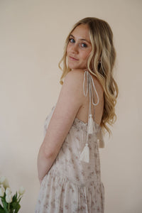 side view of model wearing the move along dress. model has the dress paired with the dainty mallory necklace.